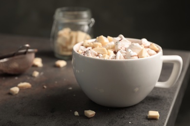 Photo of Tasty hot chocolate with milk and marshmallows in cup on table