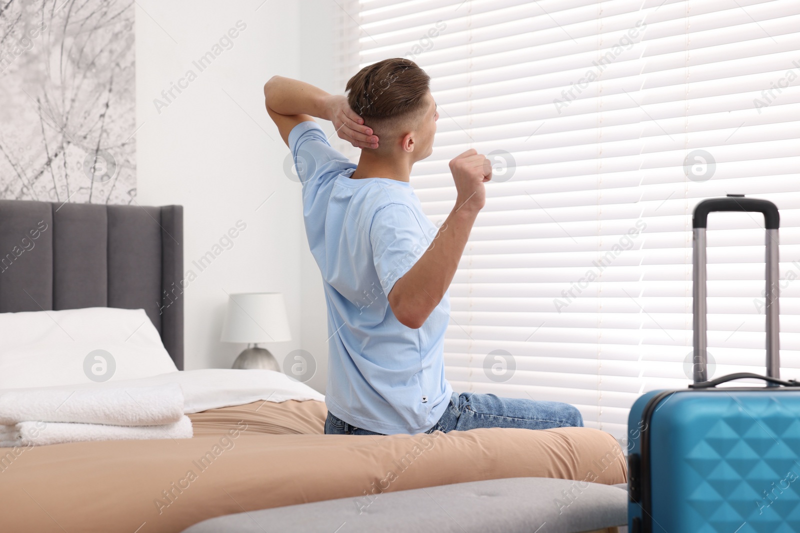 Photo of Guest stretching on bed in stylish hotel room