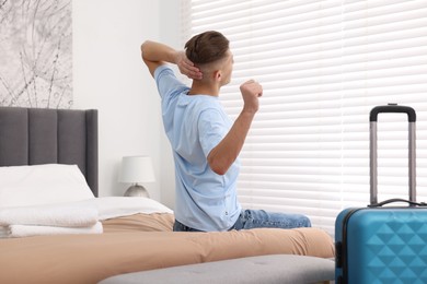 Photo of Guest stretching on bed in stylish hotel room