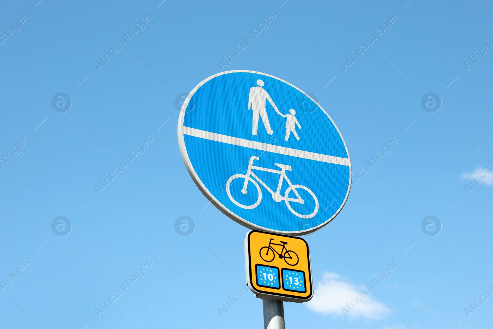 Photo of Different traffic signs against blue sky, low angle view