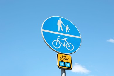 Different traffic signs against blue sky, low angle view