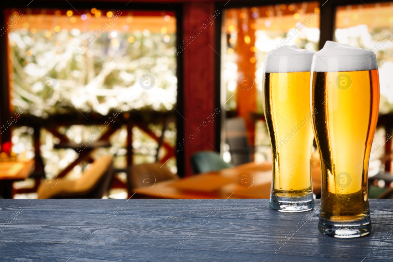 Image of Fresh cold beer on wooden table in pub, space for text