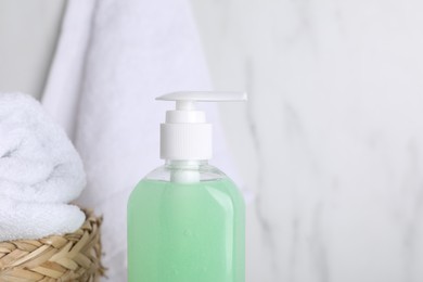 Photo of Bottle of face cleansing product on light background, closeup. Space for text