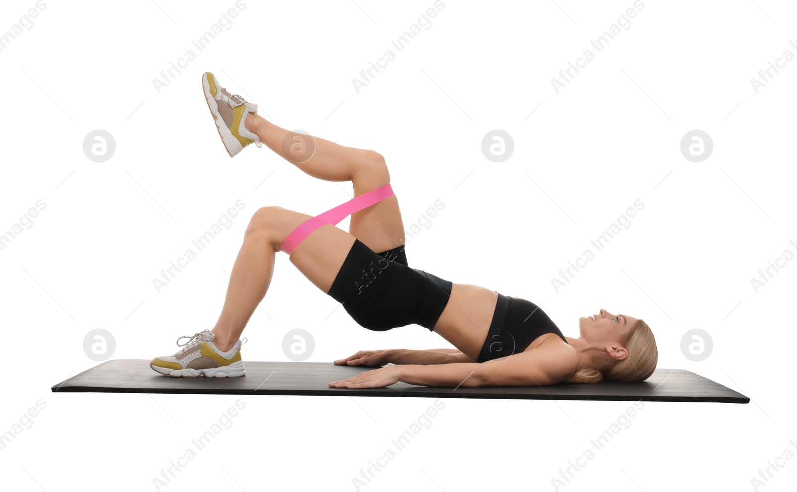 Photo of Woman exercising with elastic resistance band on fitness mat against white background