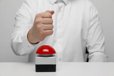 Photo of Man with red button of nuclear weapon at white table, closeup and space for text. War concept