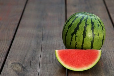Photo of Whole and cut delicious ripe watermelons on wooden table. Space for text