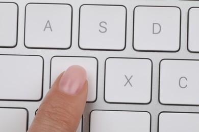 Photo of Top view of woman pressing button on computer keyboard, closeup