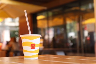Photo of MYKOLAIV, UKRAINE - AUGUST 11, 2021: Cold McDonald's drink on table in cafe. Space for text