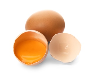 Photo of Cracked and whole chicken eggs on white background