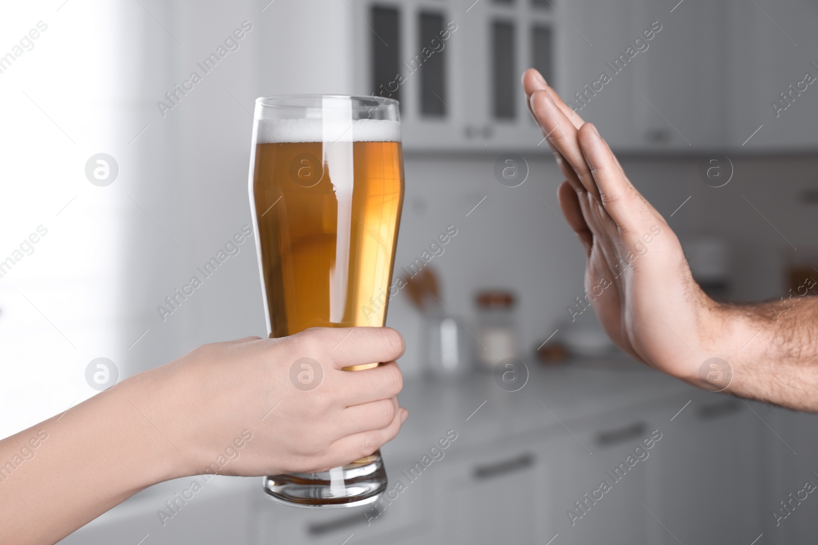 Photo of Man refusing to drink beer in kitchen, closeup. Alcohol addiction treatment