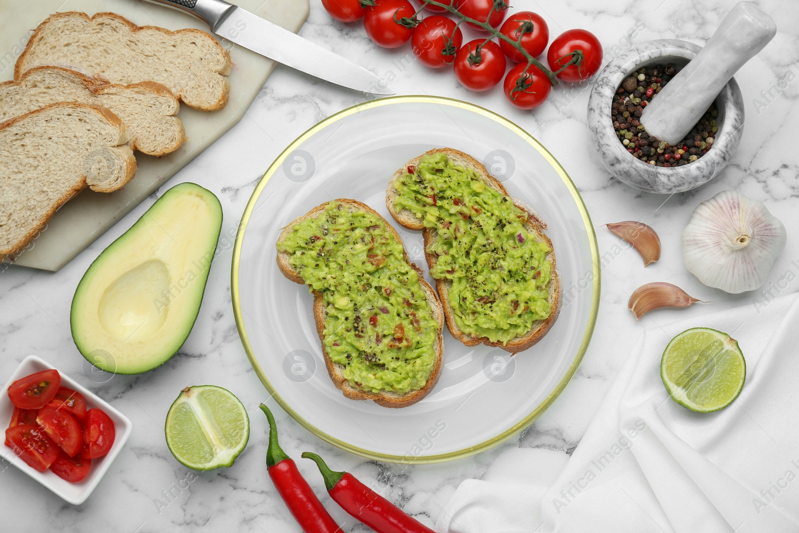 Photo of Delicious sandwiches with guacamole and ingredients on white marble table, flat lay