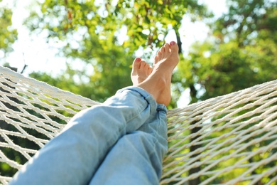 Young woman resting in comfortable hammock at green garden, closeup