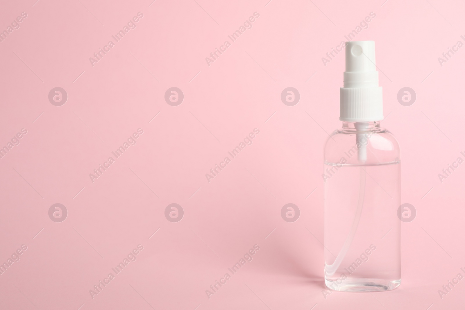 Photo of Antiseptic spray on pink background. Space for text