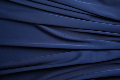 Photo of Crumpled dark blue silk fabric as background, top view