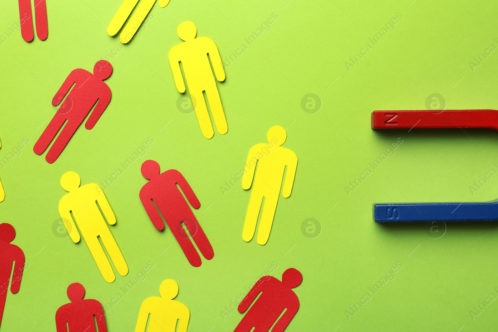 Photo of Magnet attracting paper people on color background, flat lay. Marketing concept