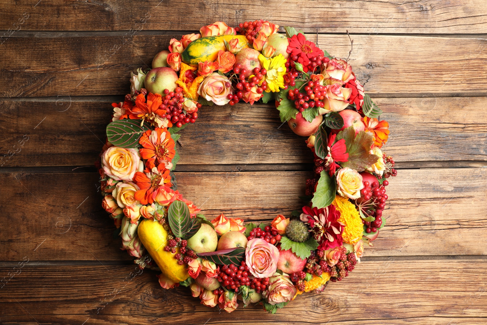 Photo of Beautiful autumnal wreath with flowers, berries and fruits on wooden background, top view. Space for text