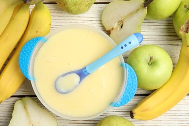 Photo of Baby food in bowl and fresh ingredients on white wooden table, flat lay