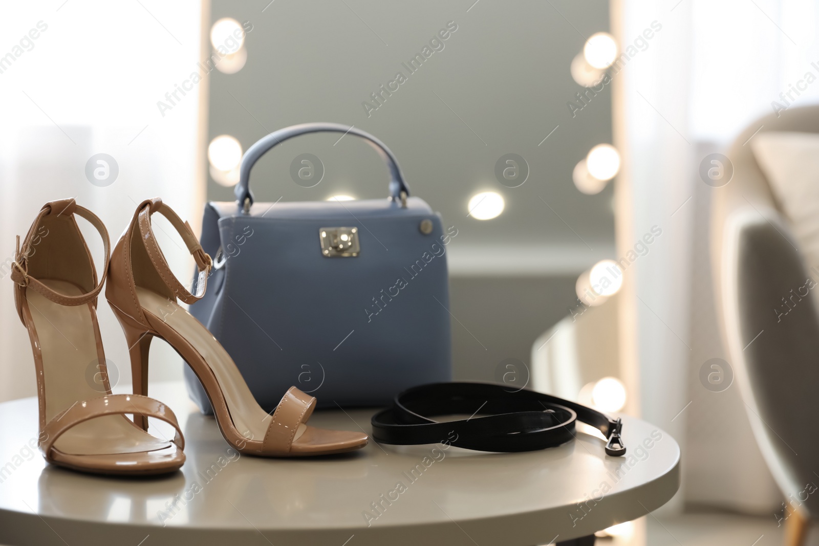 Photo of Stylish women's shoes, belt and bag in modern boutique