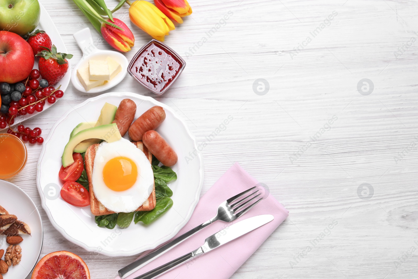 Photo of Delicious breakfast with fried egg served on white wooden table, flat lay. Space for text