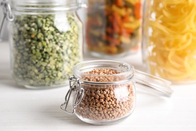 Photo of Uncooked buckwheat in jar on white table