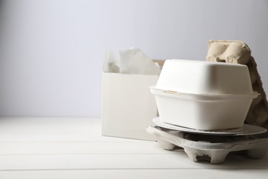 Photo of Heap of waste paper on white wooden table, space for text