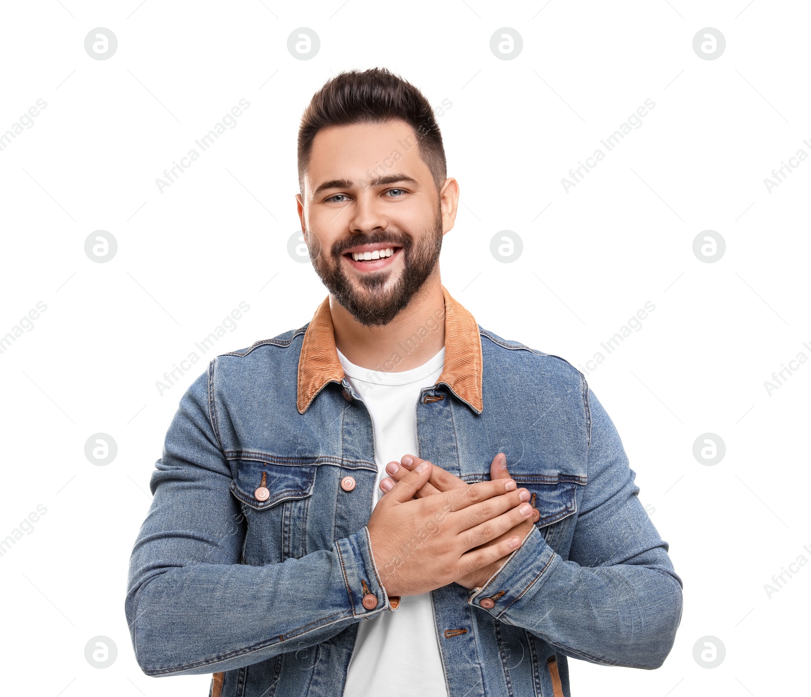 Photo of Thank you gesture. Happy grateful man holding hands near heart on white background