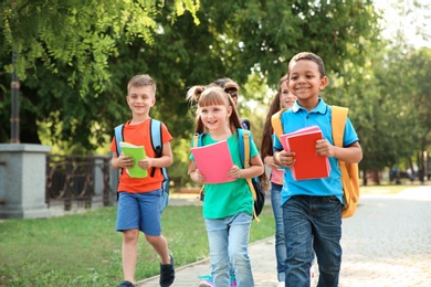 Photo of Cute little children with backpacks going to school