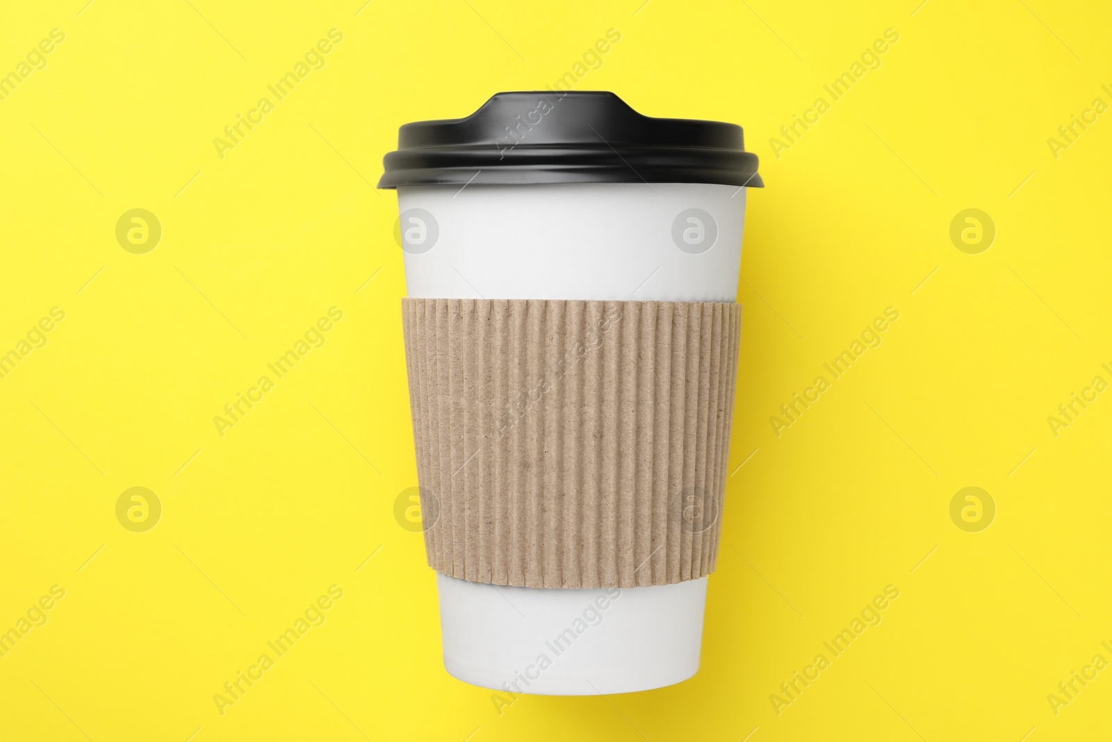 Photo of One paper cup on yellow background, top view. Coffee to go