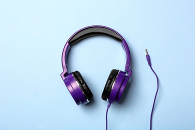 Photo of Stylish modern headphones on color background, top view