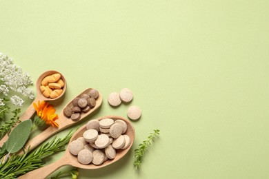 Photo of Different pills, herbs and flowers on light green background, flat lay with space for text. Dietary supplements