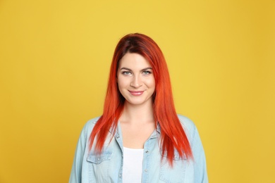Photo of Young woman with bright dyed hair on yellow background