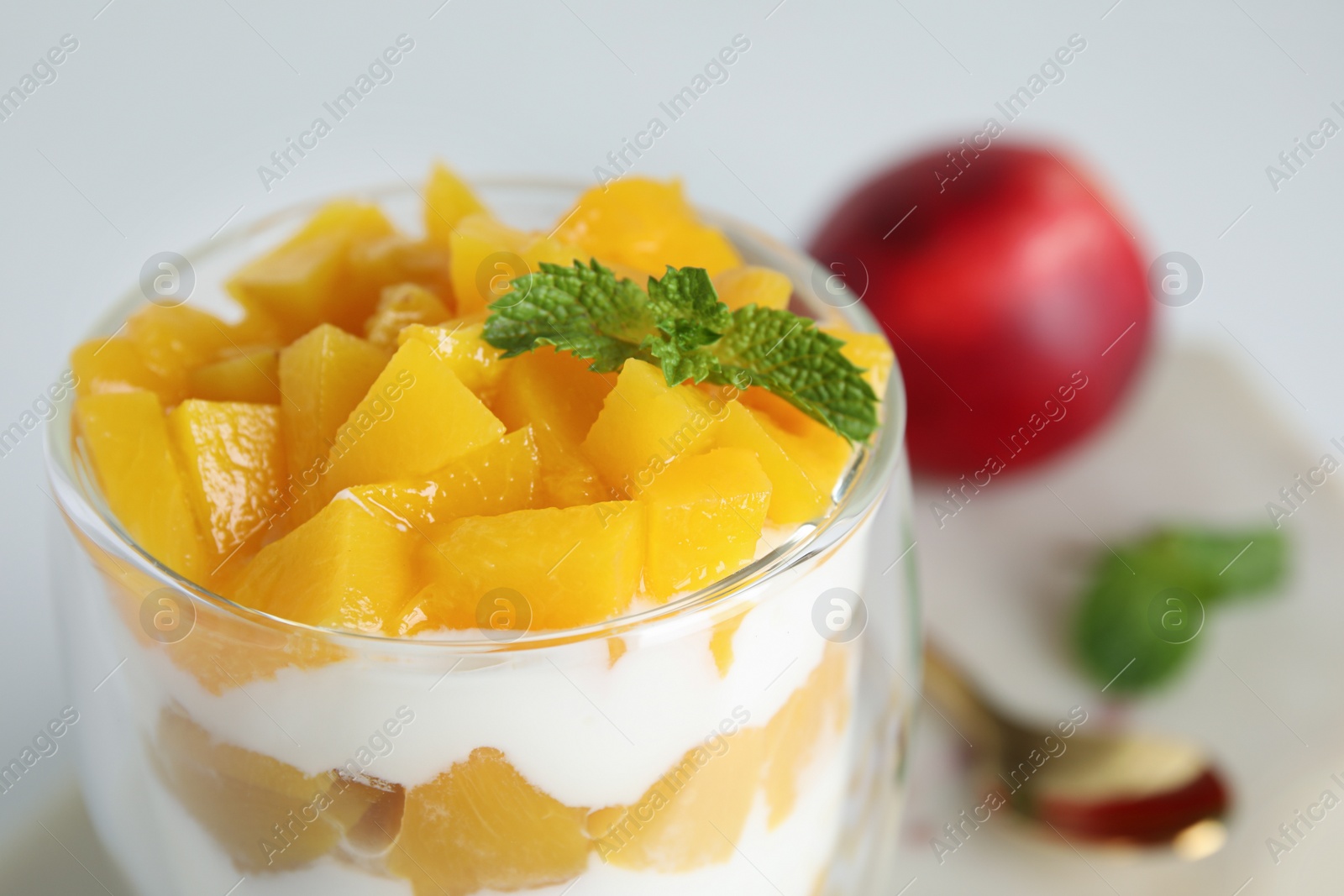 Photo of Tasty peach dessert with yogurt on table, closeup