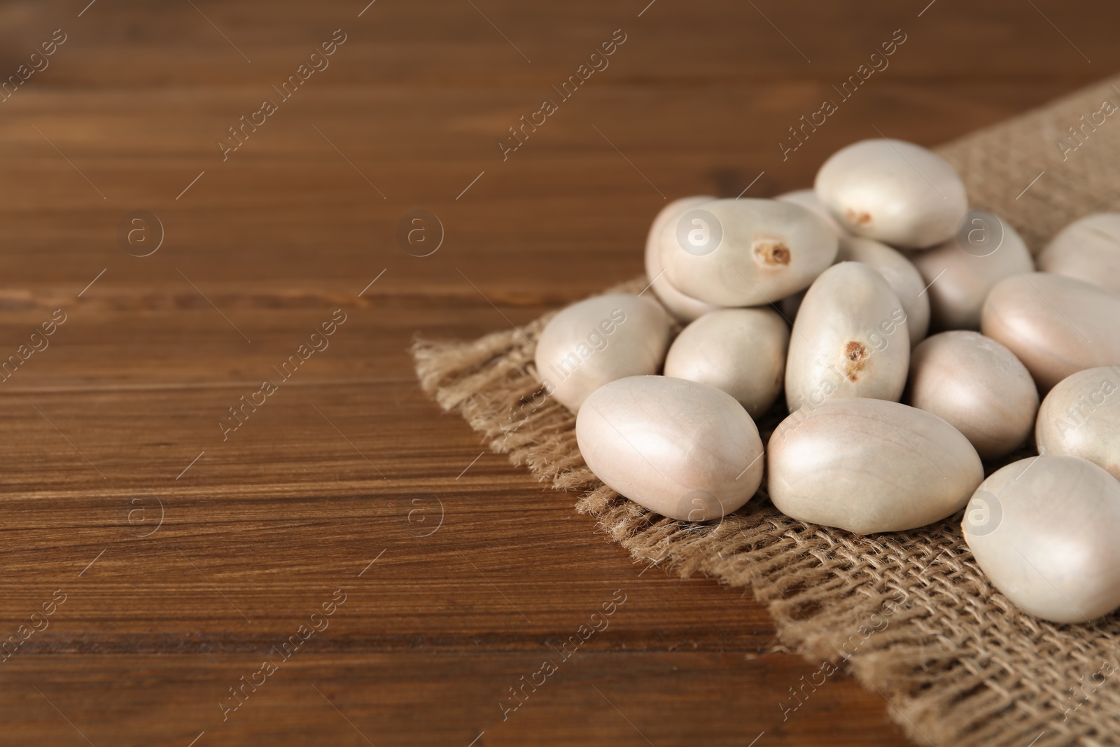 Photo of Raw jackfruit seeds on wooden table. Space for text
