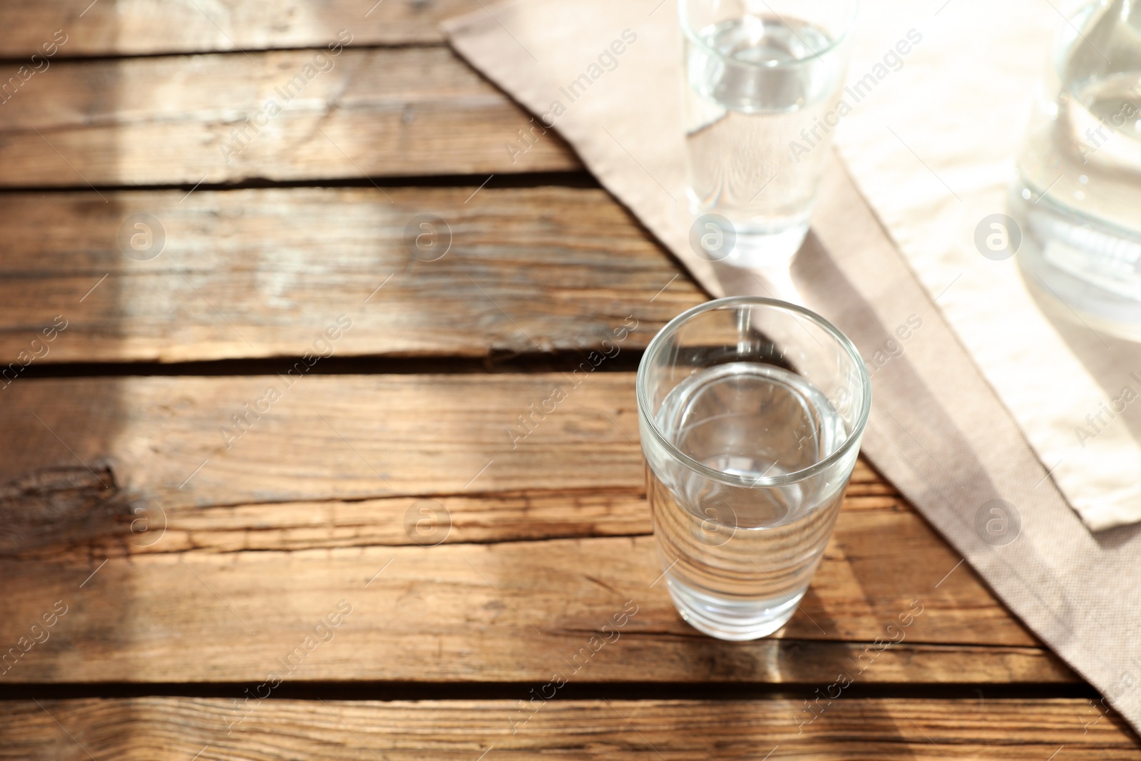 Photo of Glassware of fresh water on wooden table. Space for text