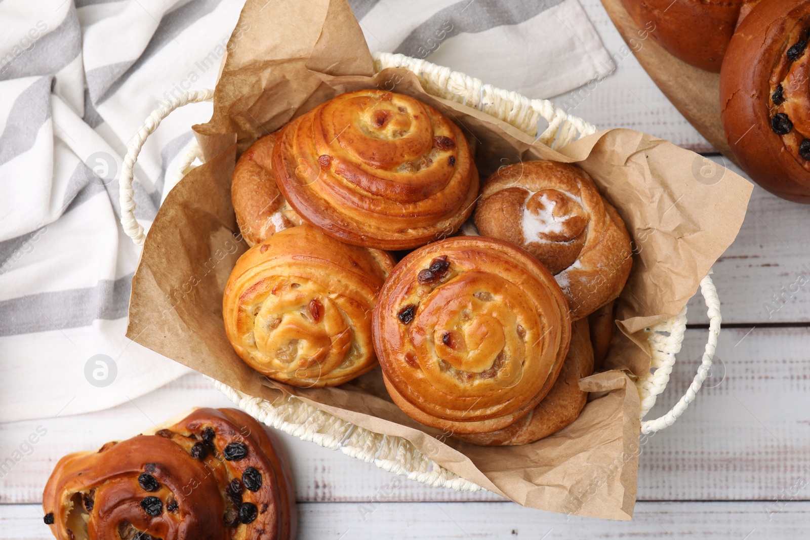 Photo of Different delicious rolls on white wooden table, flat lay. Sweet buns