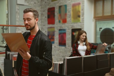 Image of Young man with vinyl record in store
