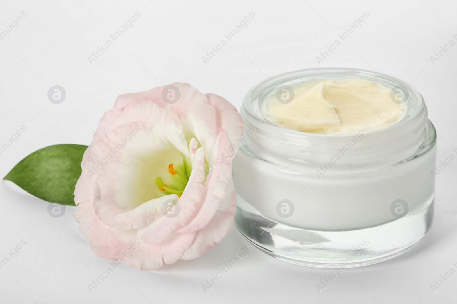 Photo of Jar with cream and flower on white background. Hand care cosmetics