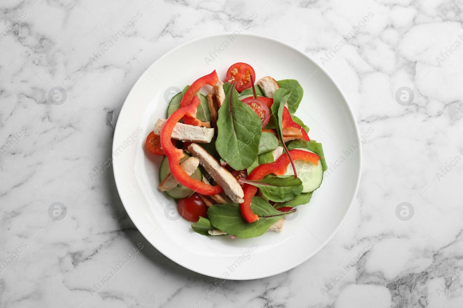 Photo of Delicious fresh chicken salad served on white marble table, top view