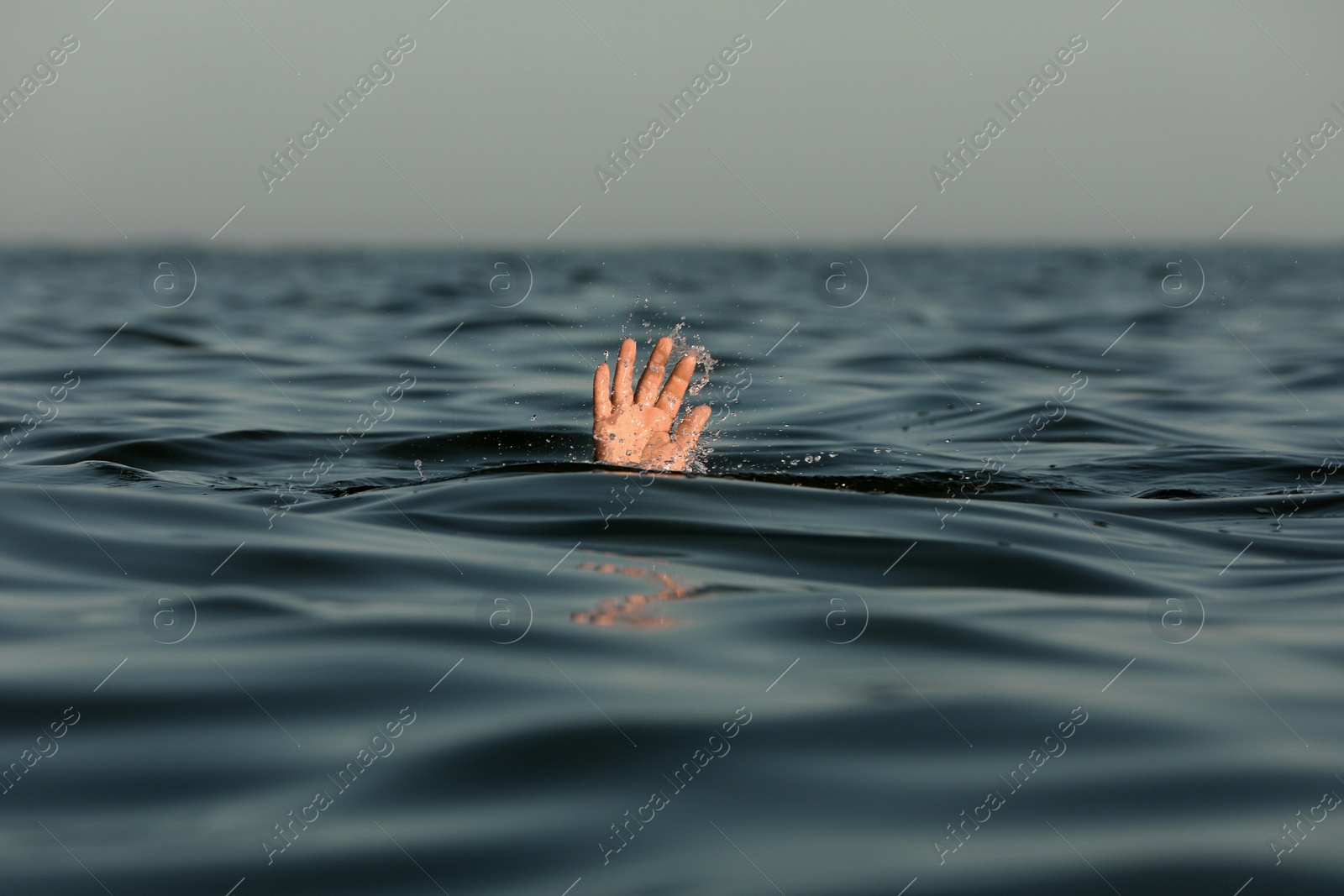 Photo of Drowning man reaching for help in sea