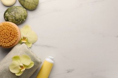 Photo of Flat lay composition with spa products and beautiful flowers on white marble table. Space for text