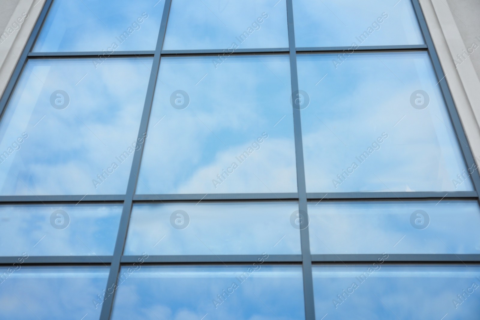 Photo of Modern building with tinted windows, low angle view. Urban architecture