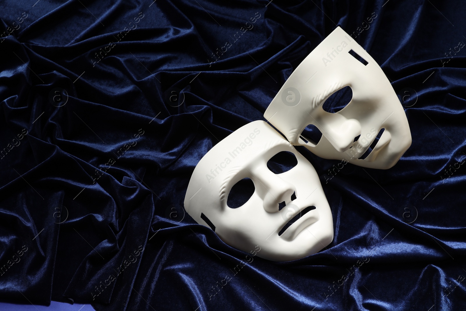 Photo of Theater arts. White masks on blue fabric, above view. Space for text