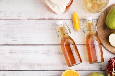 Photo of Tasty kombucha and fresh fruits on white wooden table, flat lay. Space for text