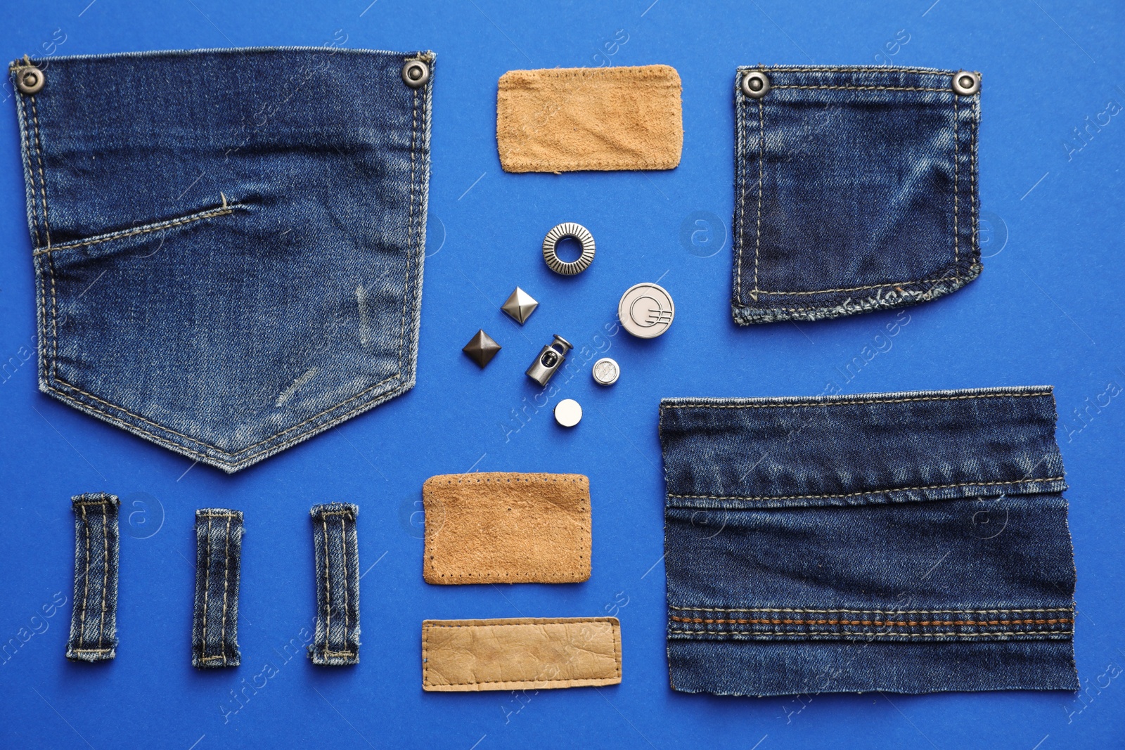 Photo of Flat lay composition with garment accessories and cutting details for jeans on blue background