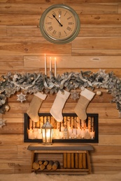 Photo of Festive room interior with decorative fireplace and Christmas stockings