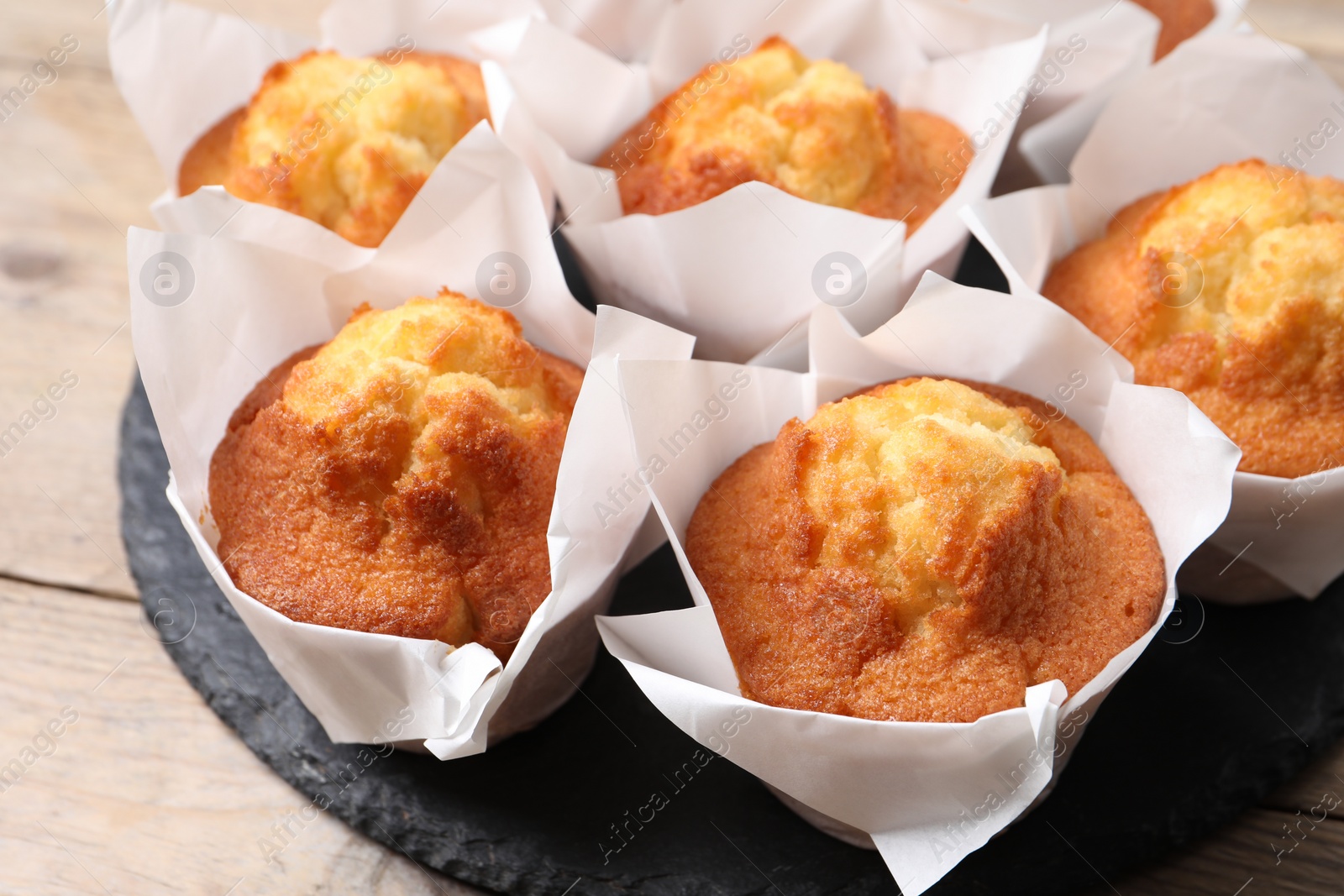 Photo of Delicious sweet muffins on wooden table, closeup