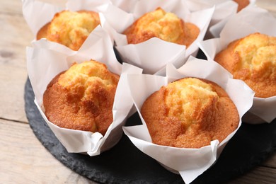 Delicious sweet muffins on wooden table, closeup