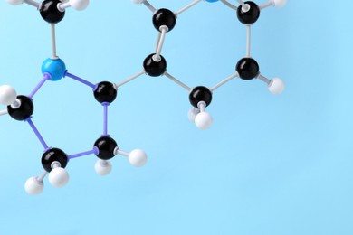 Photo of Molecule of nicotine on light blue background, closeup and space for text. Chemical model