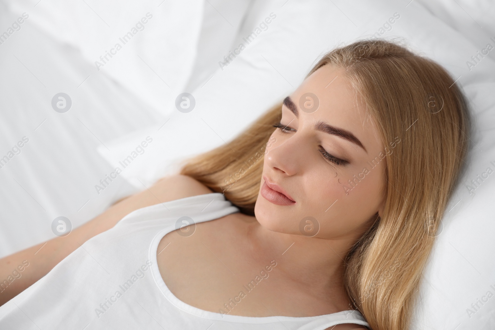 Photo of Young woman with eyelash loss problem resting in bed