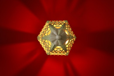 Photo of Decorative Arabic lantern on red background, top view